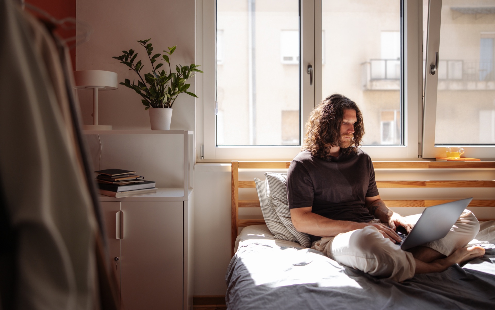 A person working on a laptop in a sunlit room